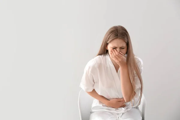 Mujer embarazada que sufre de toxicosis en el fondo de luz — Foto de Stock