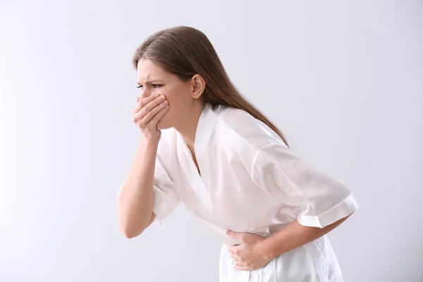 Pregnant woman suffering from toxicosis on light background — Stock Photo, Image