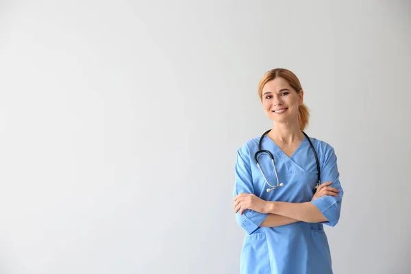 Portrait of beautiful gynecologist on light background — Stock Photo, Image