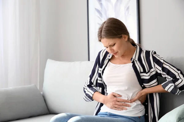 Young woman suffering from pain at home — Stock Photo, Image