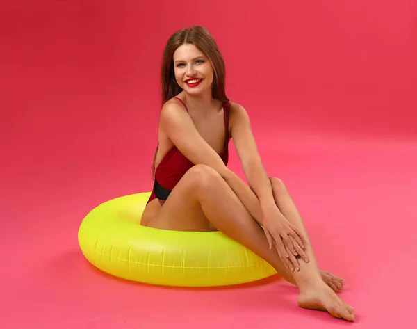 Beautiful young woman with inflatable ring on color background — Stock Photo, Image