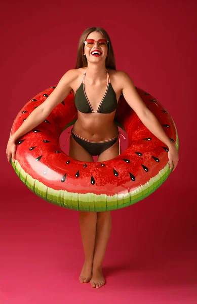 Hermosa mujer joven con anillo inflable sobre fondo de color — Foto de Stock