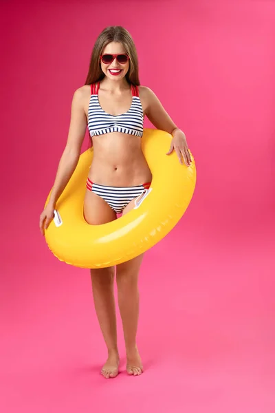 Beautiful young woman with inflatable ring on color background — Stock Photo, Image