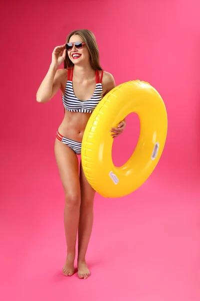 Beautiful young woman with inflatable ring on color background — Stock Photo, Image