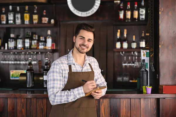 Jovem garçom masculino com caderno em restaurante — Fotografia de Stock