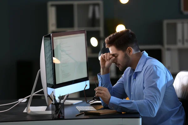 Trött manlig programmerare som arbetar på kontoret — Stockfoto