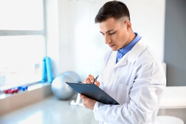 Young male physiotherapist in rehabilitation center — Stock Photo, Image