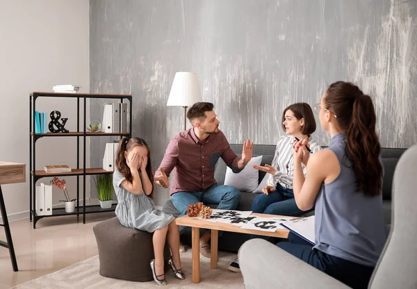 Unhappy family visiting psychologist in office