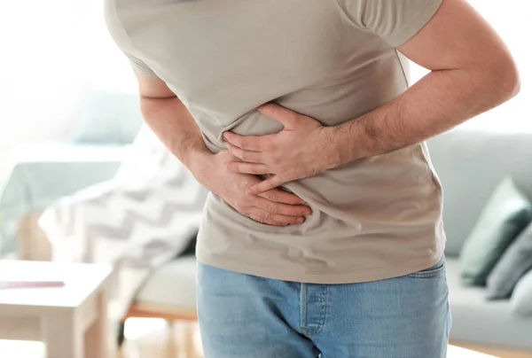 Junger Mann leidet zu Hause unter Bauchschmerzen — Stockfoto