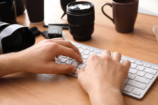 Professional photographer working on computer at table, closeup — Stock Photo, Image
