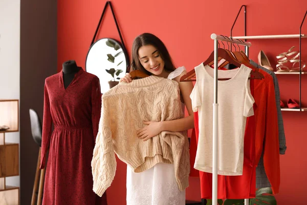 Jovem mulher escolhendo roupas no camarim — Fotografia de Stock