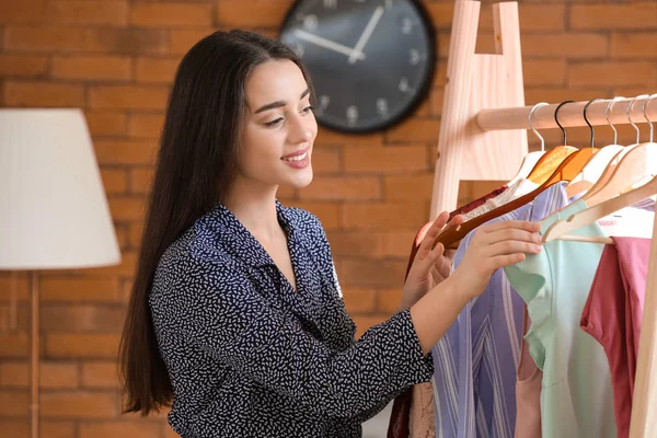 Mujer joven eligiendo ropa en vestidor — Foto de Stock