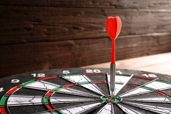 Dartboard com alvo atingido na mesa, close-up — Fotografia de Stock