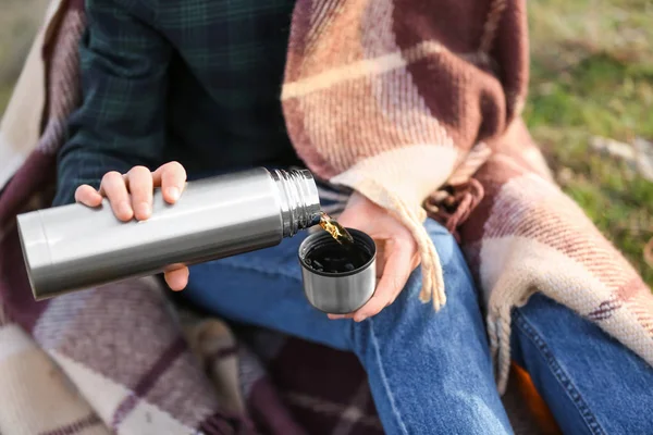 Woman drinking hot tea from thermos outdoors — Stock Photo, Image