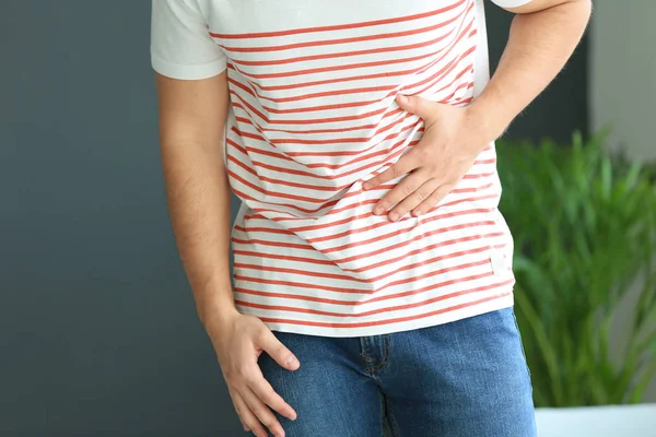Young man suffering from stomachache at home — Stock Photo, Image