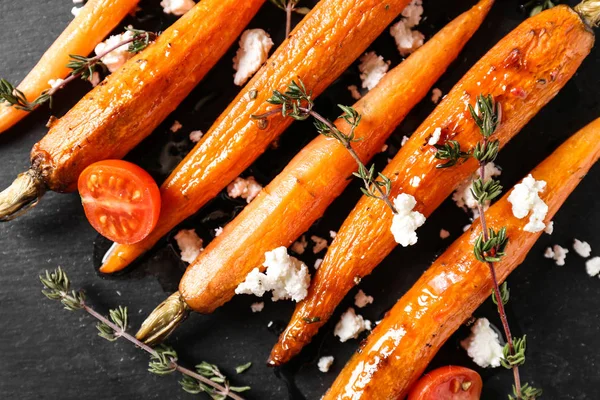 Cooked carrot on slate plate, closeup