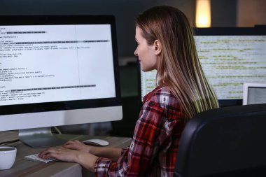 Geceleri ofiste çalışan kadın programcı.