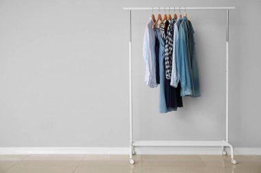 Gri duvara yakın şık giysilerile Raf