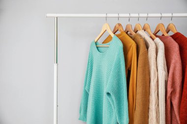 Gri arka planda şık giysiler ilerler