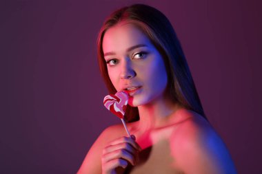 Renkli arka planda lezzetli lolipop ile güzel genç kadının tonda portre