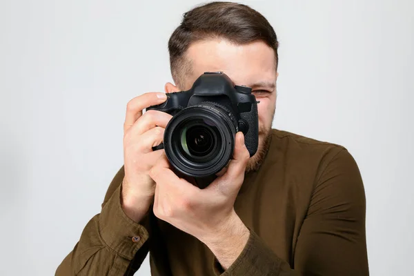 Male photographer on light background — Stock Photo, Image