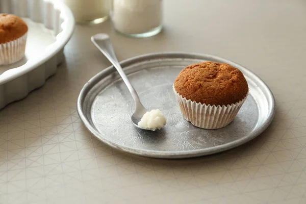 Kokosöl mit leckerem Muffin auf dem Tisch — Stockfoto