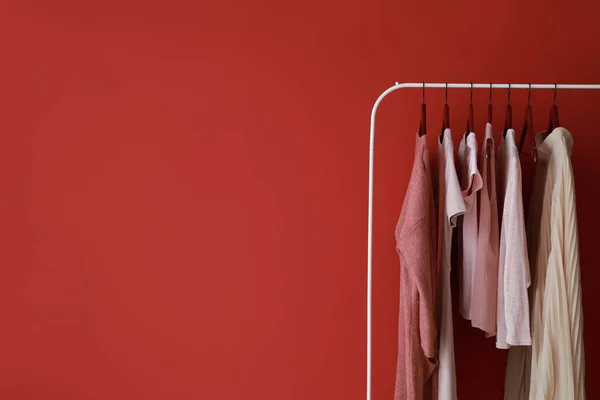 Cremalheira com roupas elegantes no fundo de cor — Fotografia de Stock