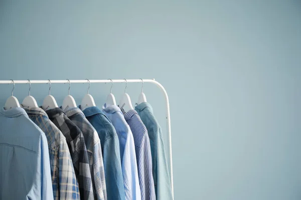 Rack with stylish clothes on grey background — Stock Photo, Image