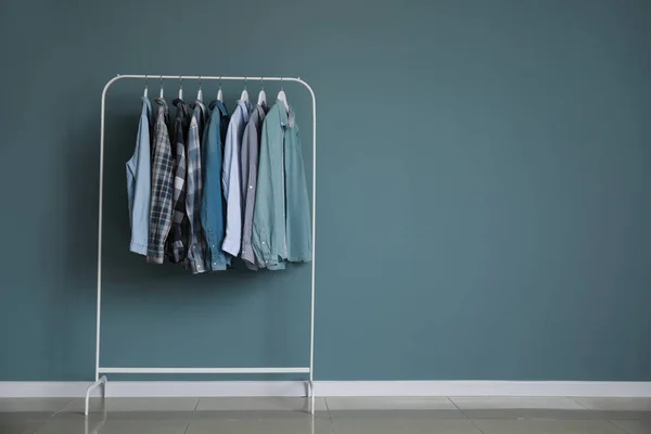 Bastidor con ropa elegante cerca de la pared gris —  Fotos de Stock