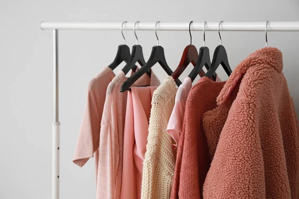 Rack with stylish clothes on grey background — Stock Photo, Image