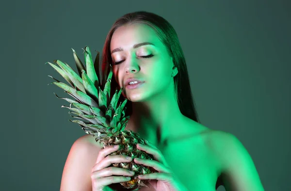 Ritratto tonico di bella giovane donna con gustoso ananas su sfondo di colore — Foto Stock