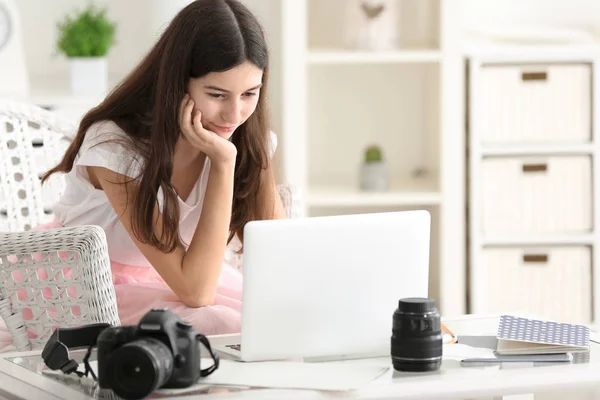 Young female photographer with laptop at home — Stock Photo, Image