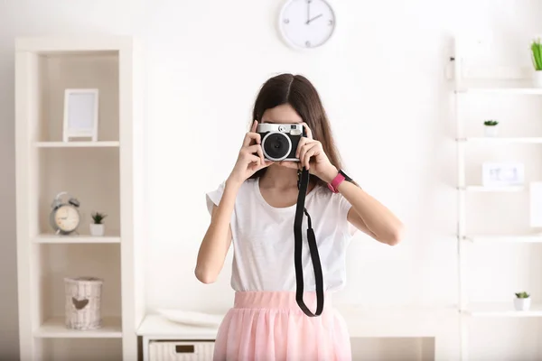 Jeune fille avec appareil photo à la maison — Photo