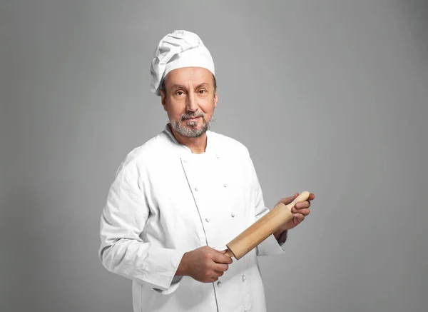 Portrait of handsome mature chef on grey background — Stock Photo, Image