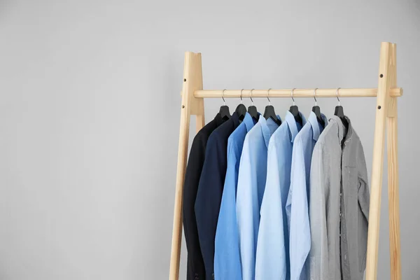 Rack med snygga manliga kläder på ljus bakgrund — Stockfoto