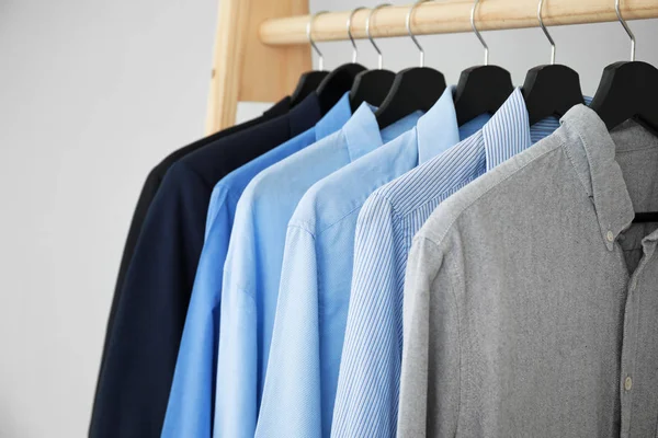 Kleiderbügel mit Männerkleidung auf hellem Hintergrund, Nahaufnahme — Stockfoto