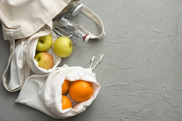 Bawełniane torby ze świeżych owoców na szarym tle. Koncepcja zero odpadów — Zdjęcie stockowe