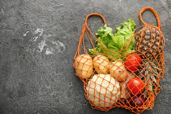 グランジを背景にメッシュショッピングバッグと新鮮な野菜とパイナップル。廃棄物ゼロの概念 — ストック写真