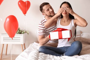 Genç bir kadın erkek arkadaşından hediye alıyor.