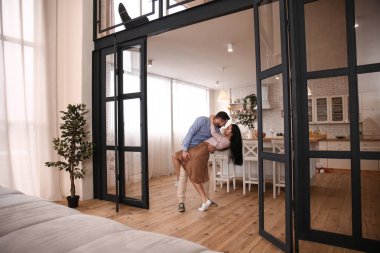 Mutlu genç çift evde dans ediyor.