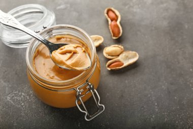 Gri masada lezzetli fıstık ezmesi ile Kavanoz