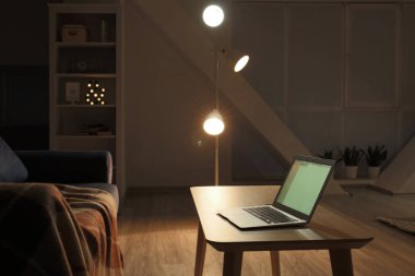Gece oturma odasının iç masada Modern dizüstü bilgisayar