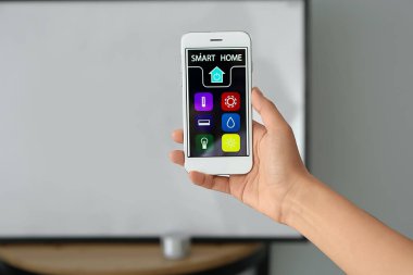 Akıllı ev otomasyonu uygulamasını kullanan genç Asyalı kadın