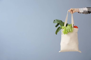 Gri arka plan üzerinde eko çanta ile Kadın el. Sıfır atık kavramı
