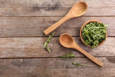 Ahşap masa üzerinde lezzetli taze arugula ile Bowl