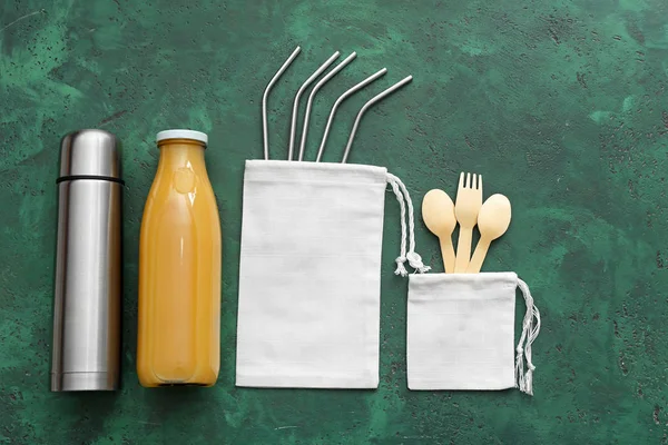 カトラリー、ストロー、ジュースのボトル、色の背景にサーモスを持つバッグ。廃棄物ゼロの概念 — ストック写真