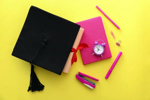 Mortar board, diploma and stationery on color background. Concept of high school graduation — Stock Photo, Image