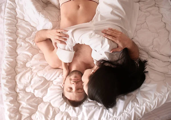Mutlu genç bir çift yatakta yatarken — Stok fotoğraf