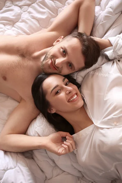 Felice giovane coppia sdraiata sul letto — Foto Stock