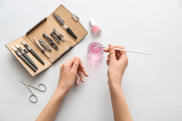 Woman doing manicure on light background — Stock Photo, Image